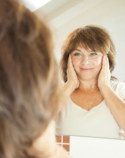 older woman looking in mirror